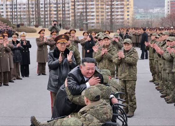 One of them looked visibly emotional as Kim held his head and hand while he sat in a wheelchair in a military uniform. Other images showed Kim consoling families of the deceased and kneeling before a portrait of a fallen soldier to pay his respects, placing what appeared to be medals and flowers beside images of the dead. The North Korean leader also mentioned the "pain of waiting for one hundred and twenty days in which he had never forgotten the beloved sons even for a moment". In September, Kim appeared alongside Chinese President Xi Jinping and Russian President Vladimir Putin at an elaborate military parade in Beijing. Kim did not respond to an offer from Donald Trump to meet during the US president's Asia trip in October.