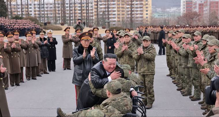One of them looked visibly emotional as Kim held his head and hand while he sat in a wheelchair in a military uniform. Other images showed Kim consoling families of the deceased and kneeling before a portrait of a fallen soldier to pay his respects, placing what appeared to be medals and flowers beside images of the dead. The North Korean leader also mentioned the "pain of waiting for one hundred and twenty days in which he had never forgotten the beloved sons even for a moment". In September, Kim appeared alongside Chinese President Xi Jinping and Russian President Vladimir Putin at an elaborate military parade in Beijing. Kim did not respond to an offer from Donald Trump to meet during the US president's Asia trip in October.